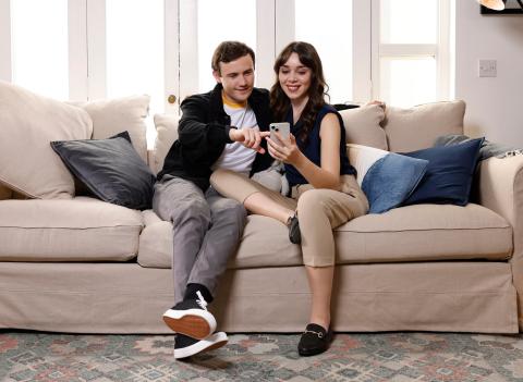 Couple sitting on couch looking at their Yuno Energy app